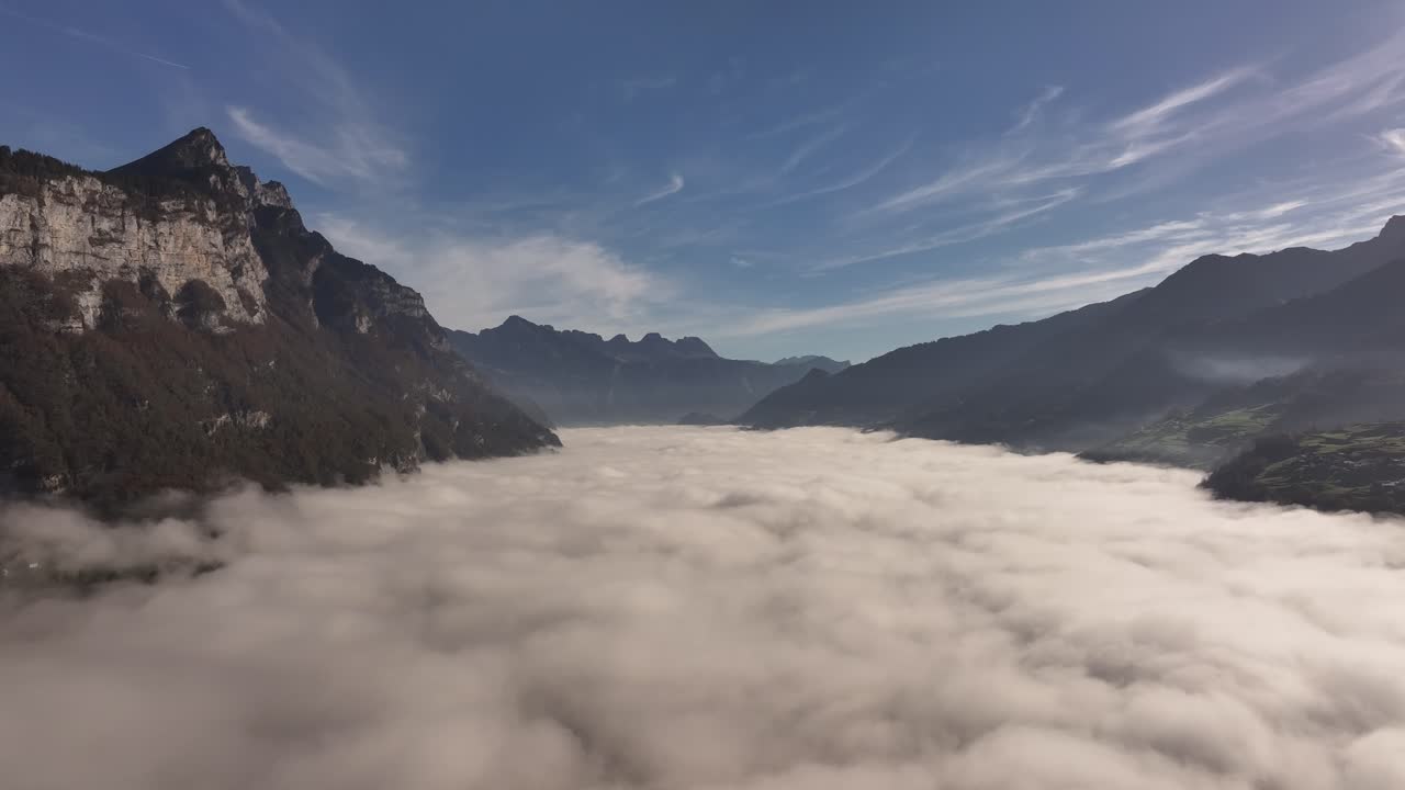 Panoramic aerial view of the Swiss Alps with a low cloud of mist.