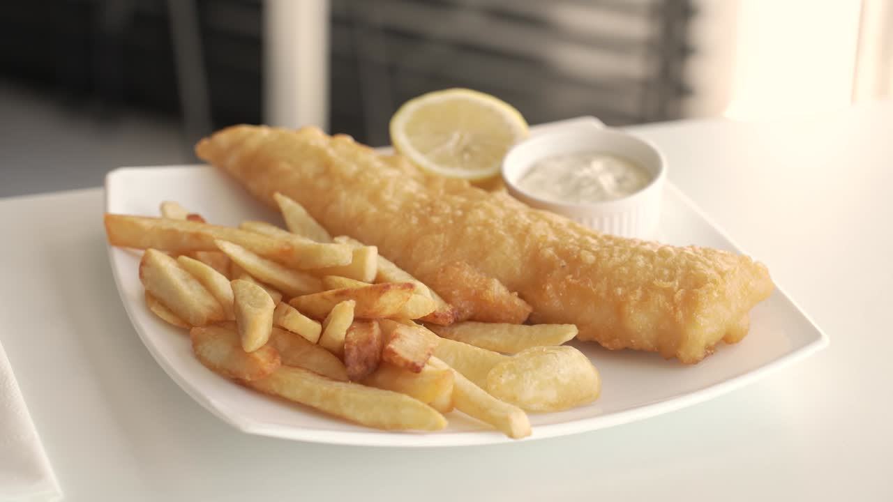 Crispy delight from the seaside dine-in featuring golden fried fish and fries with zesty lemon - Close Up Shot