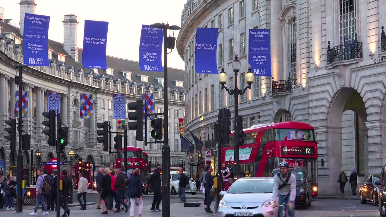 이른 저녁 2층 버스와 런던 택시 교통은 피카딜리 서커스를 통해 이동합니다.