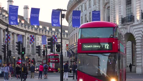 early evening doubledecker bus and london taxi traffic moves through piccadilly circus