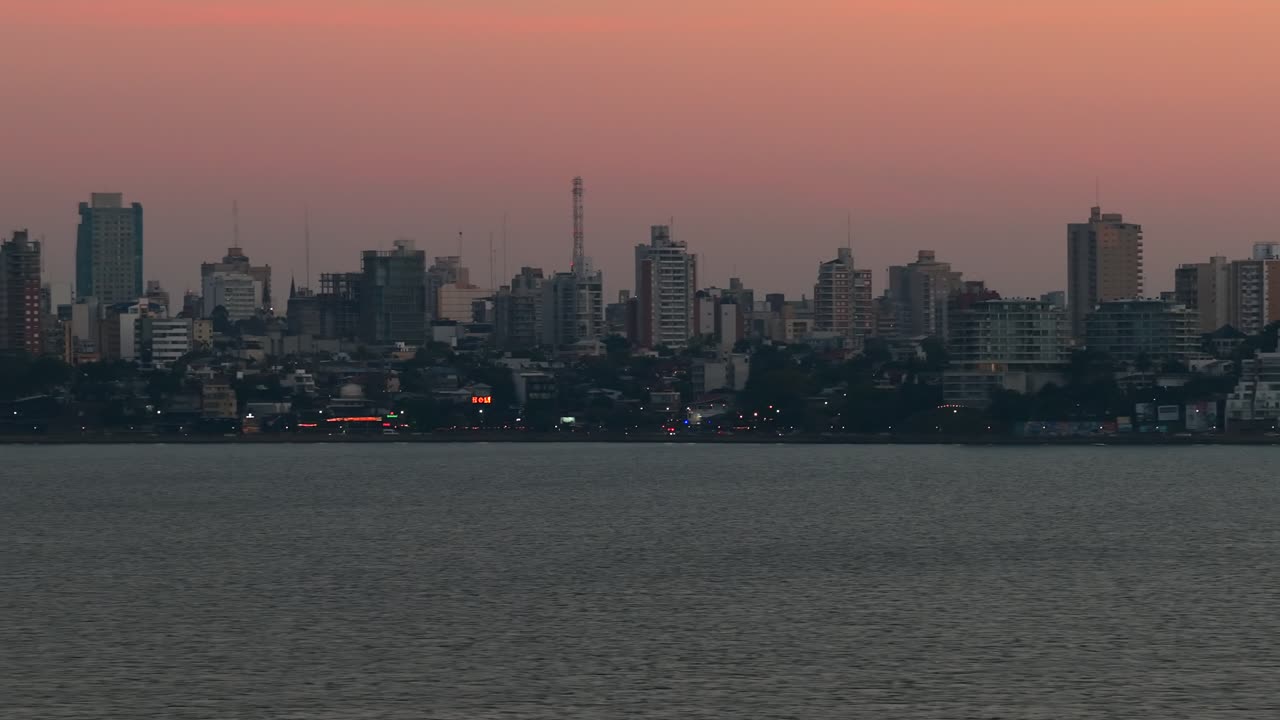 Edifici del centro della città metropolitana di Posadas, Argentina, e lungofiume al crepuscolo, con il cielo serale.