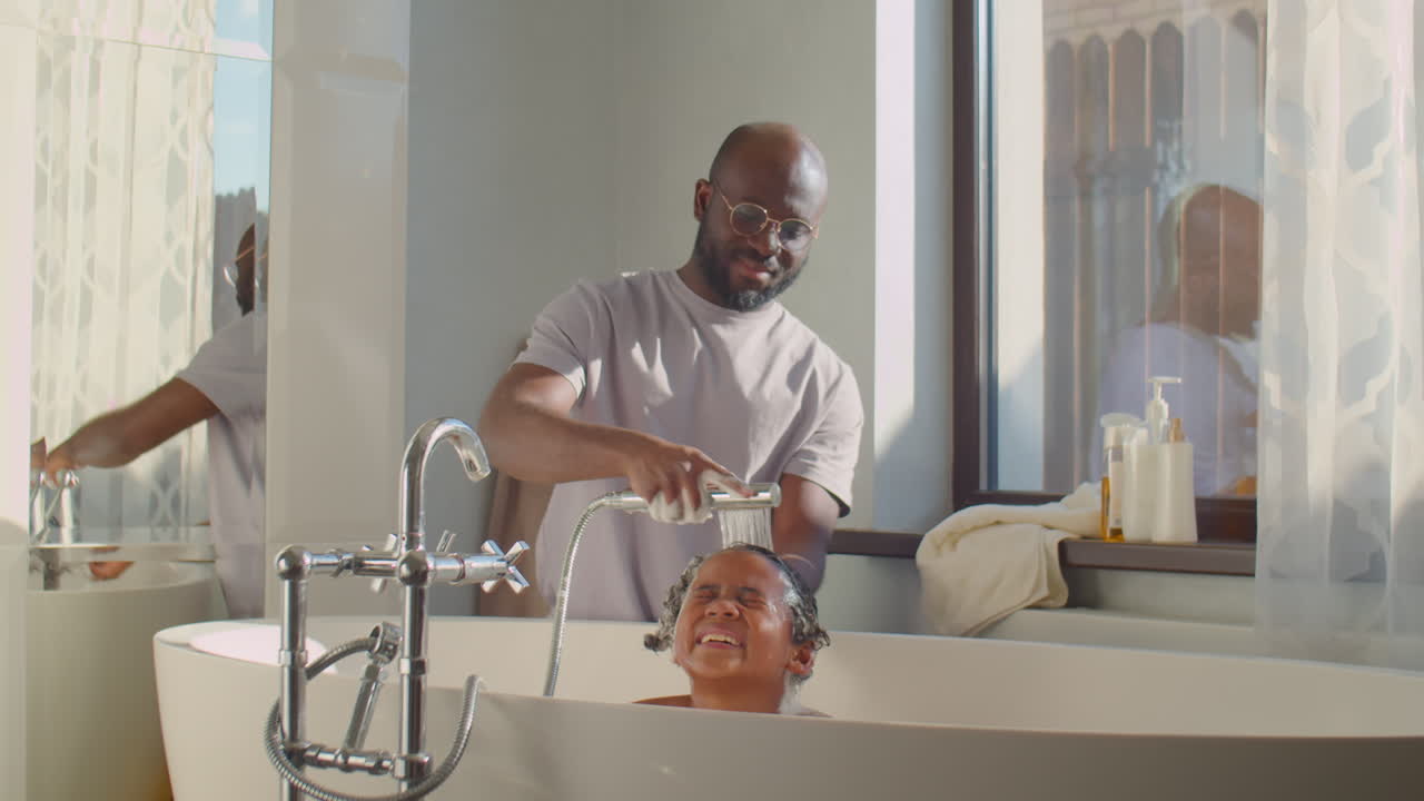 African American Father Washing Hair of Kid in Bathroom