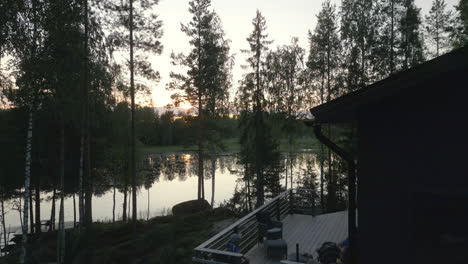 family enjoying outdoor living space in their lakefront home at sunset