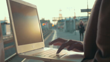 Mujer-Usando-Una-Computadora-Portátil-En-El-Andén-De-La-Estación.