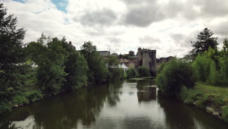 Un-Dron-De-Baja-Altura-Hacia-Adelante-Desde-El-Río-Hacia-El-Puente-De-La-Torre-Medieval