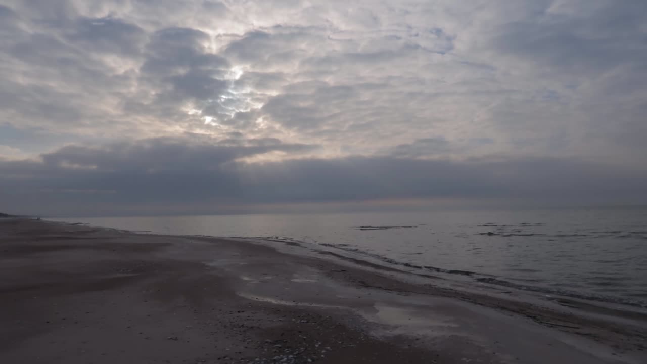 겨울에는 어두운 흐린 하늘이 있는 변덕스러운 모래 해변