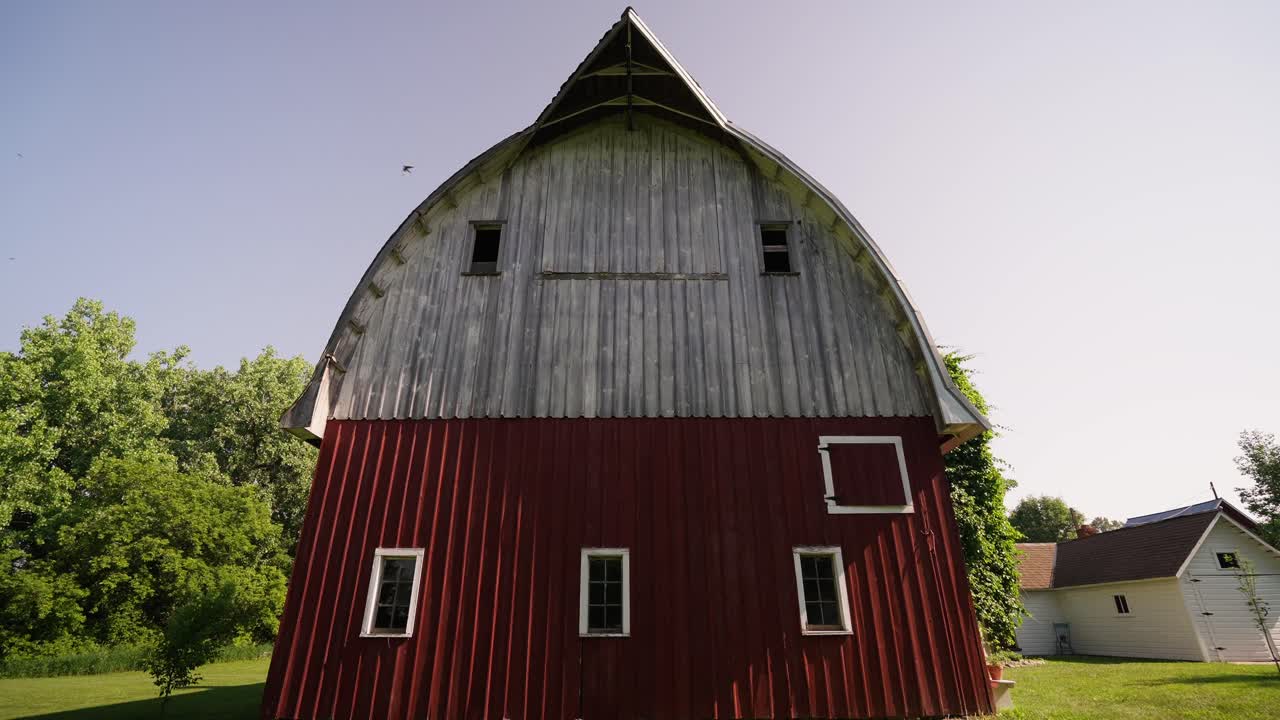 Nærbillede af en gammel rød og hvid lade på en solskinsdag med flyvende fugle.