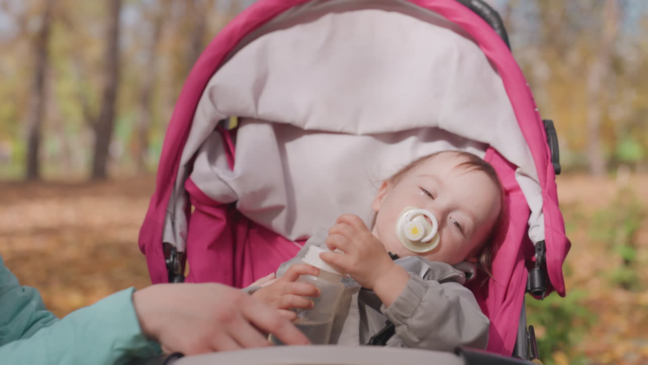 Tranquil family outdoor bonding time. Serene family moment during autumn with resting baby. Relaxing outdoor family moment where parents care for their sleeping infant during fall season