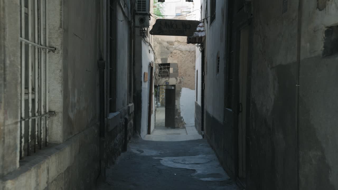 Cinematic shot of a narrow historic alley in Damascus Old City, Syria, showcasing traditional architecture, authentic street life, and Middle Eastern heritage