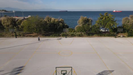 4K-drone-clip-revealing-a-basket-over-a-basketball-court-in-a-sports-complex-in-Thessaloniki,-Greece