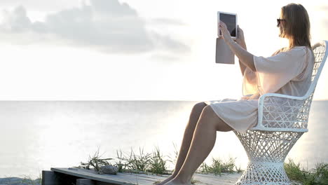 woman near the sea making photos using pad