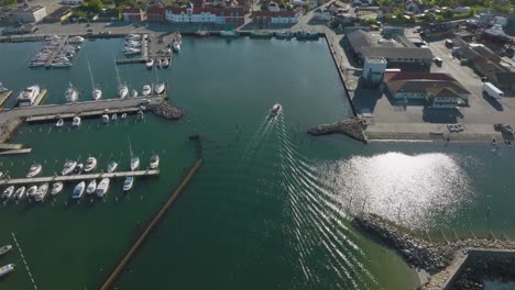 an aerial view of a small fishing port with industrial buildings, warehouses, and yachts