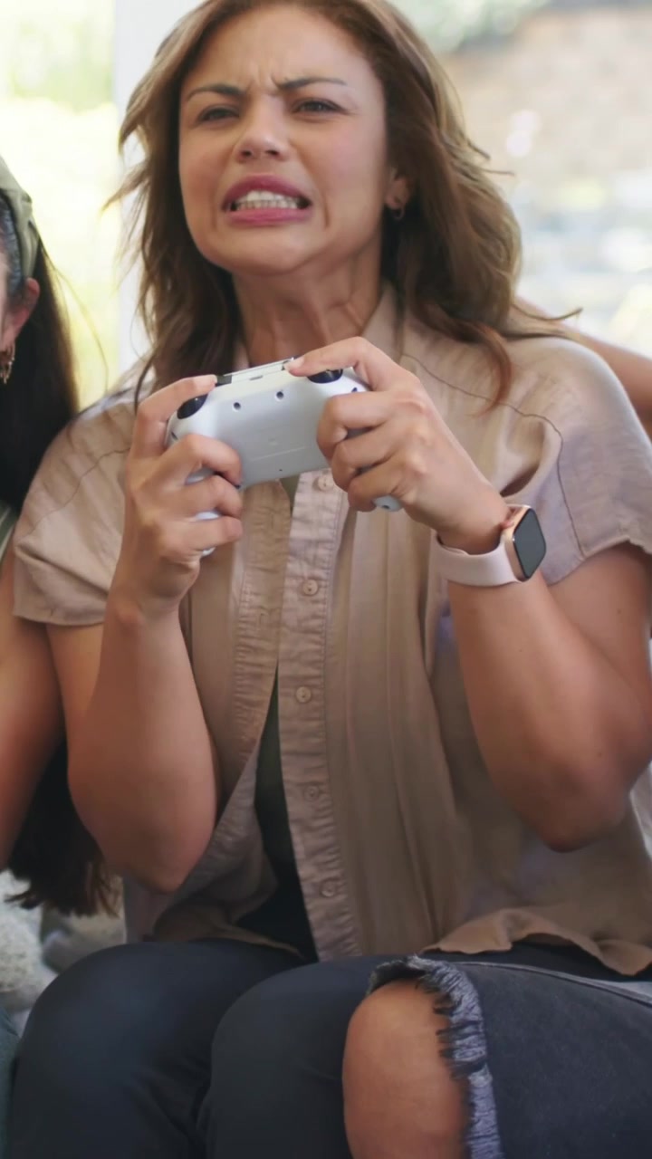 Video verticale: Donna che ride, tiene un gamepad all'inizio, tirando per allontanarsi dall'amico con la birra a casa.