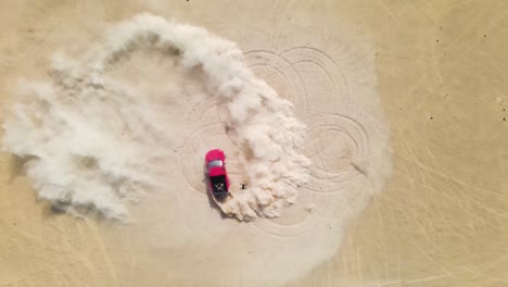 drone looking down on a red truck doing high speed doughnuts in the desert, kicking up dust