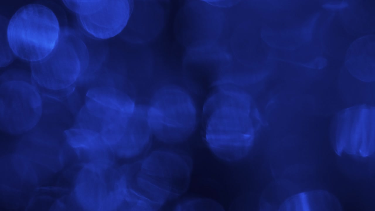 Bokeh blu increspato. Bokeh riflesso nell'acqua con gocce di pioggia che cadono