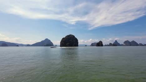 beautiful footage of a boat tour in phuket, thailand, cruising along towering limestone cliffs and tropical waters of phang nga bay, a famous travel and sightseeing destination in southeast asia