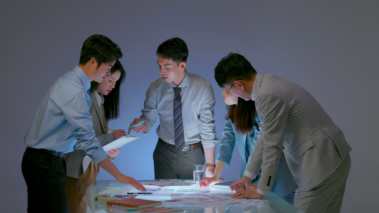 Team of business people working together at the office desk on teamwork, discussions revolving around financial charts and the management of accounts in the production cost accounting system