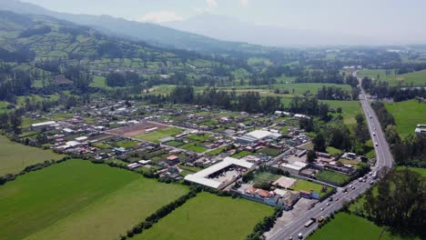 Aerial-neighbourhood-and-main-road-El-Rosal-Tambillo,-Mejía-Pichincha,-Ecuador