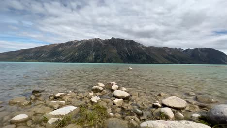 vista en ángulo bajo desde la orilla del lago glaciar turquesa y la escarpada cara de la montaña