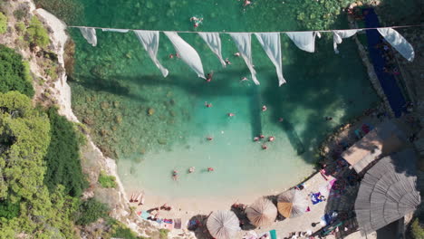 Birds-Eye-Aerial-View-of-Heavenly-Beach,-White-Sand-and-Hanging-Fabrics