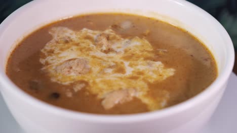 a bowl of massaman thai curry rotating with close up shot