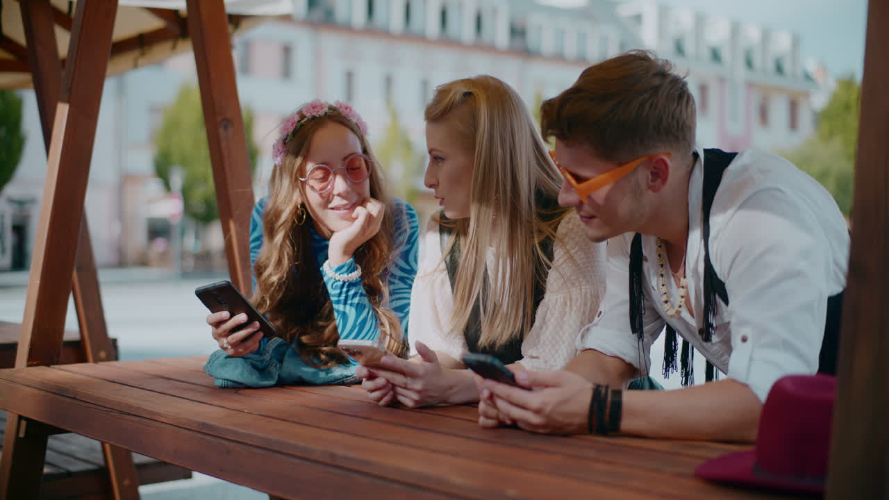 amigos interactuando en sus teléfonos en un café