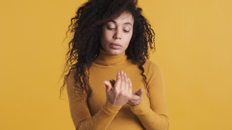 una mujer hermosa afroamericana sobre un fondo naranja.