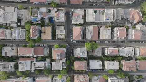 static aerial video top down of a car navigating an intersection in a neighborhood in tel aviv, israel