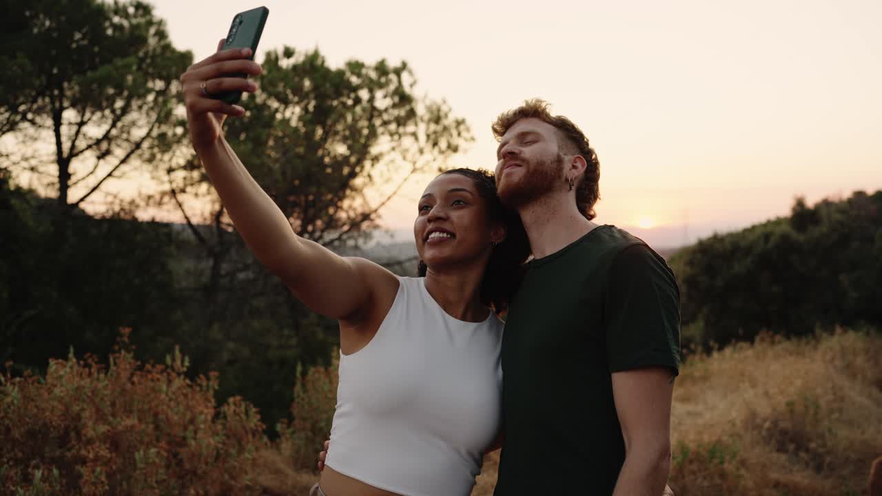 Una pareja tomando una selfie al atardecer