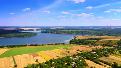 scenic sunny view of the beautiful landscape at daytime. pictorial village in greenery, farmlands and river at the backdrop of blue sky.