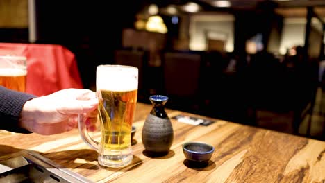 a person pours and serves a glass of beer