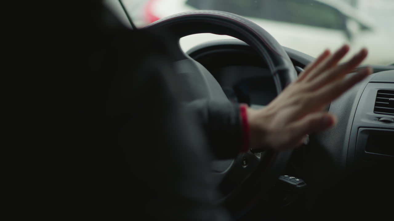 High angle view of urban driver adjusting gear shift lever inside car cabin, worn knob and quilted seat cover visible, cars passing through window, illustrating skilled manual control
