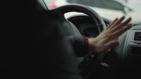 high angle view of urban driver adjusting gear shift lever inside car cabin, worn knob and quilted seat cover visible, cars passing through window, illustrating skilled manual control