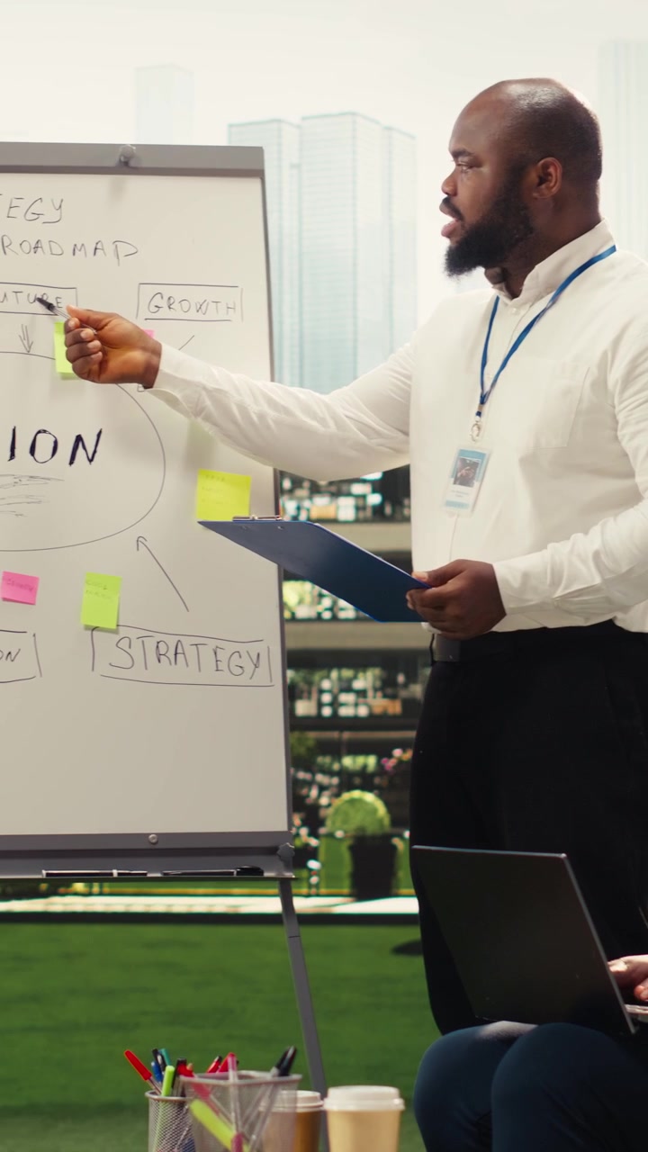 Vertical Video Diverse business presenters explaining vision board with sticky notes