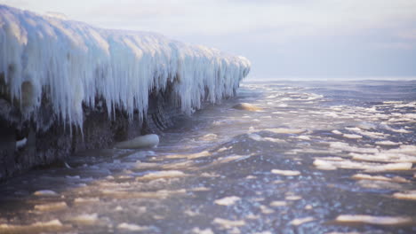 cold sea waves crashing against icy coastline, arctic icicles, global warming