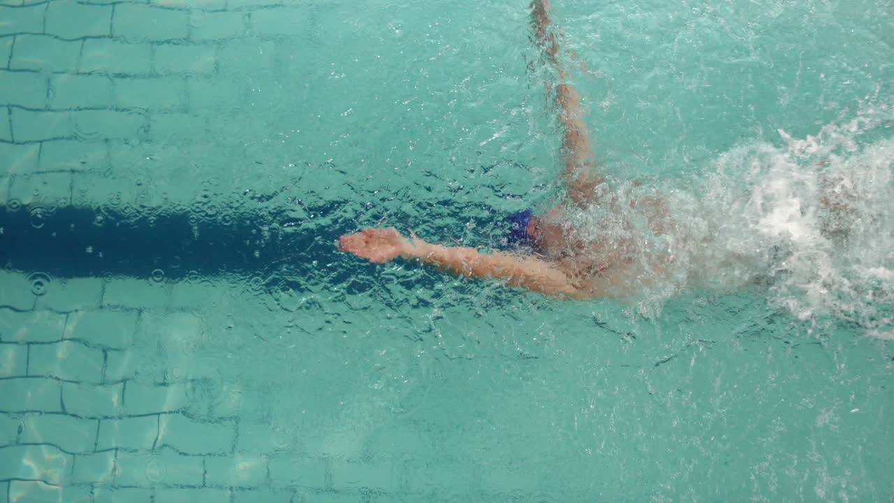 Above view of swimmer diving into pool