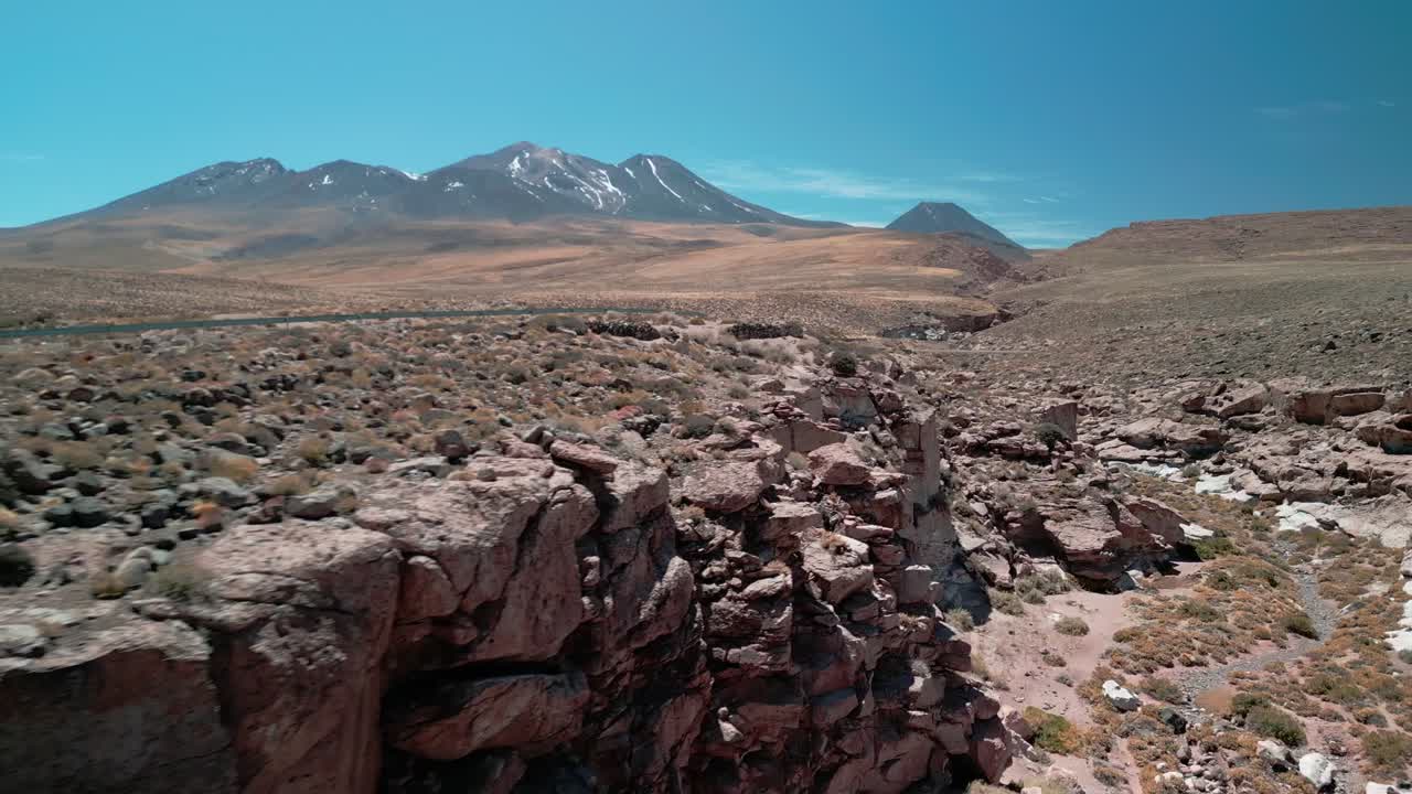 drone volando hacia atrás a través de un pequeño cañón en el desierto chileno