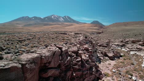 drone volando hacia atrás a través de un pequeño cañón en el desierto chileno