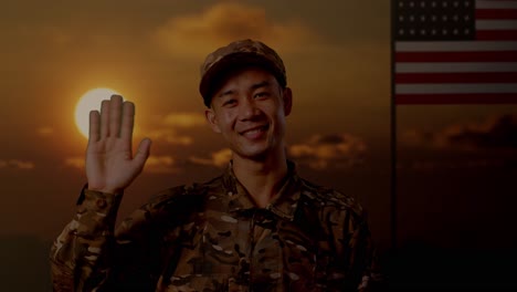 close up of asian man soldier smiling, waving hand, and saying bye while standing with flag of the united states, sunset time