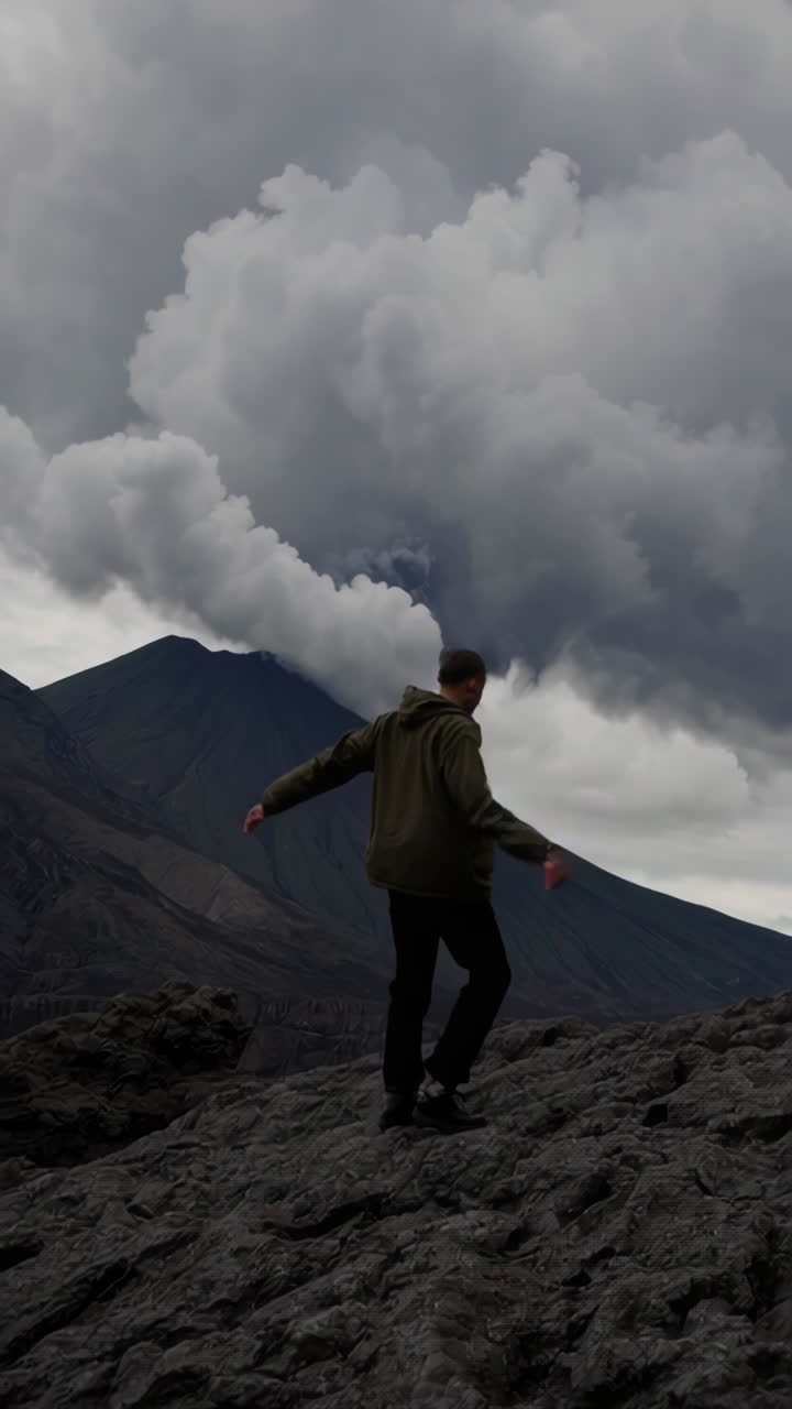 A man exploring a rugged volcanic landscape under cloudy skies
