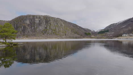 low fast flying drone above the water with rotation around a tiny island with trees on it