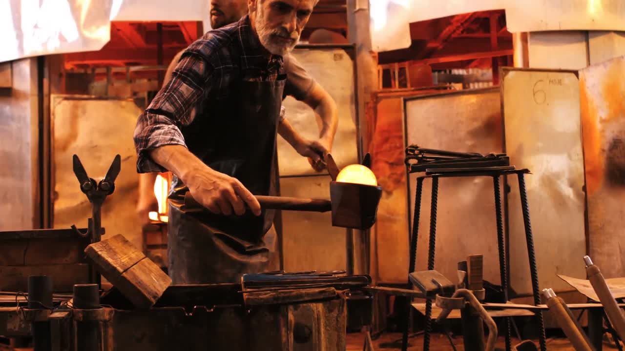 soplador de vidrio que da forma a un vidrio fundido