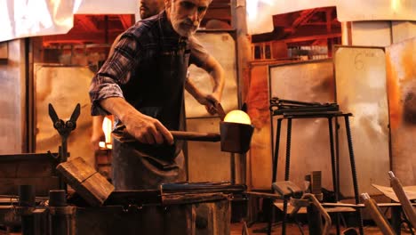 glassblower shaping a molten glass