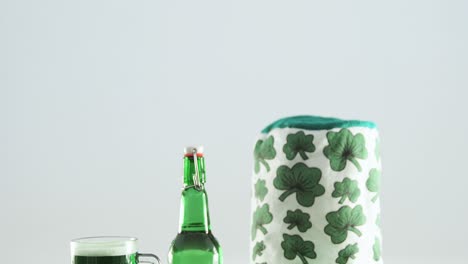 happy st patricks day message with green pint, bottle and irish hat for st patricks