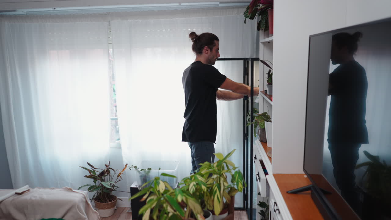 Uomo che si prende cura delle piante da interno a casa