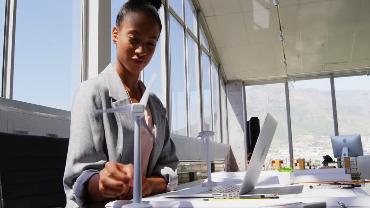 Side view of African American Businesswoman using laptop at desk in a modern office 4k