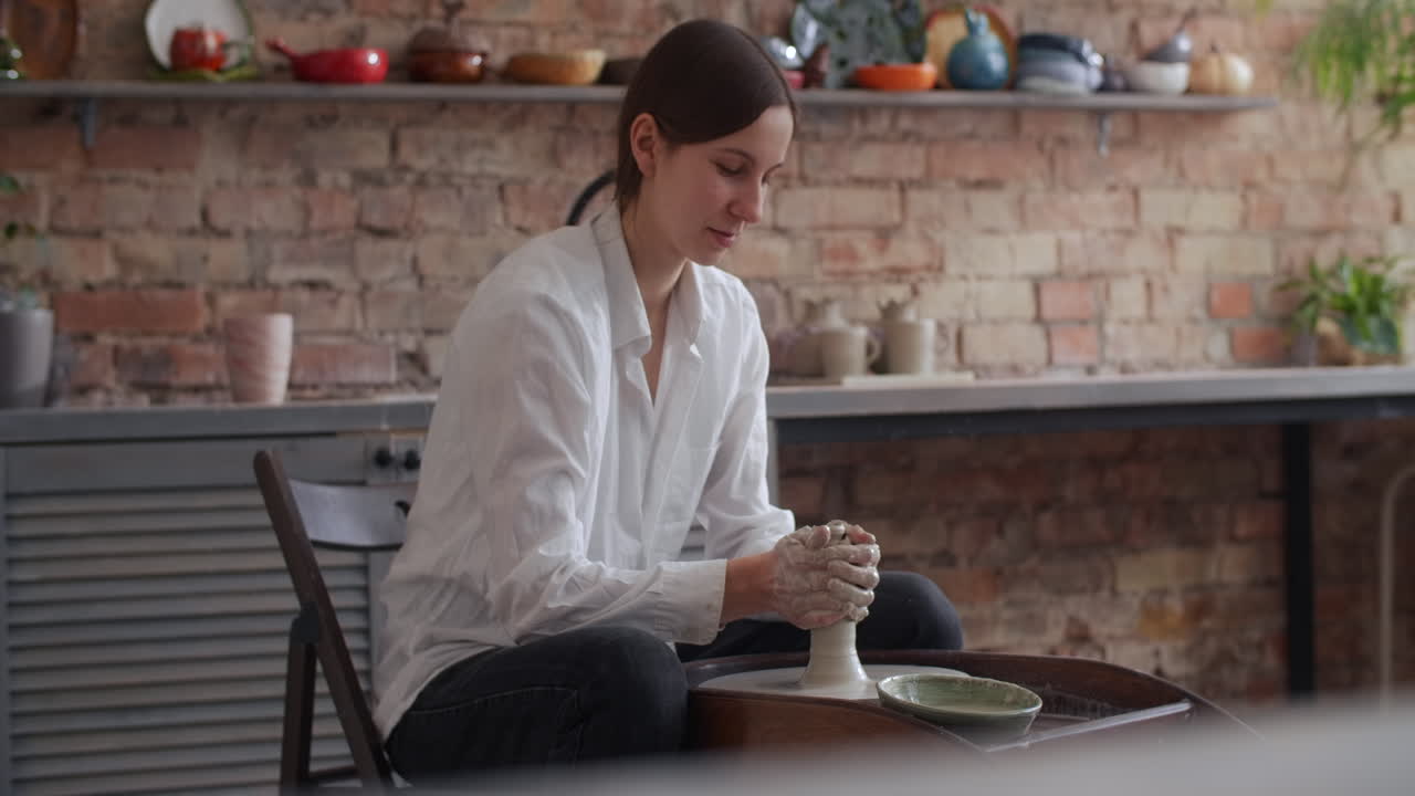 Woman working on pottery wheel in her home studio