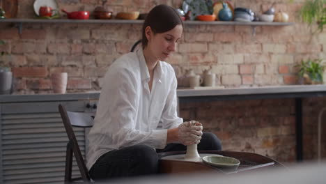 woman working on pottery wheel in her home studio