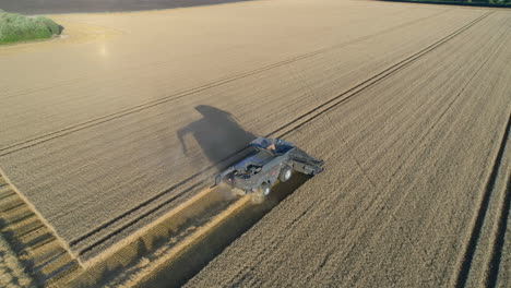 Establecimiento-De-Una-Toma-De-Drones-De-Una-Cosechadora-Con-Largas-Sombras-En-La-Hora-Dorada-Del-Atardecer-En-El-Reino-Unido