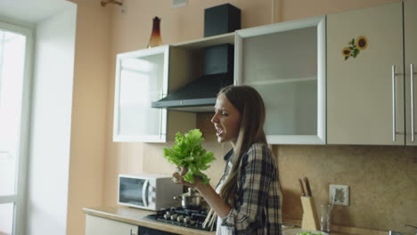 woman dancing in kitchen with salad